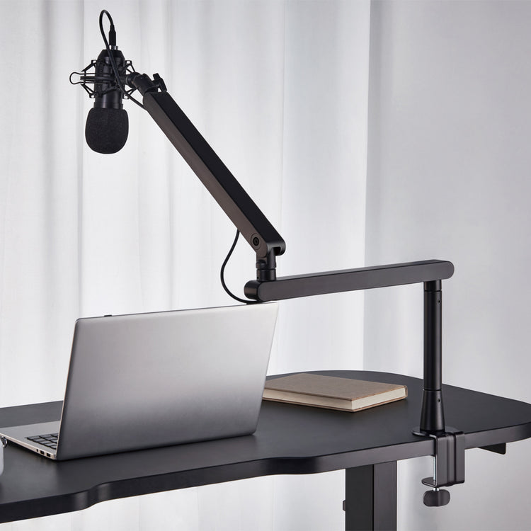 Adjustable studio microphone boom arm attached to desk 