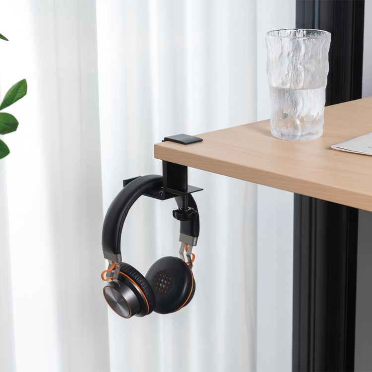 Black headphone hanger attached to desk 