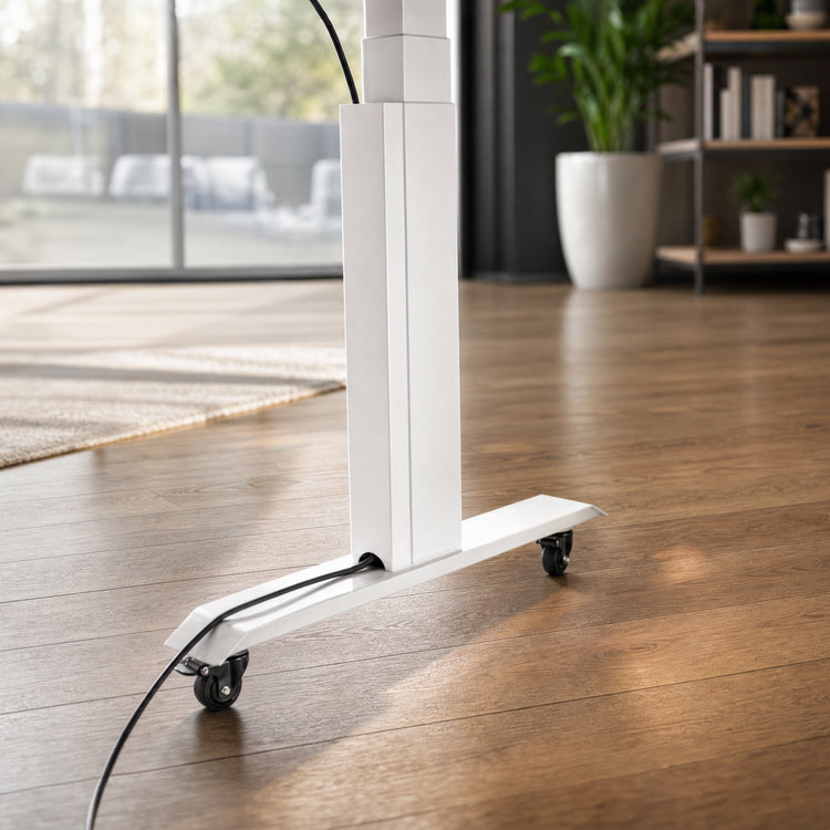 A close-up of a white electric height-adjustable desk with magnetic cable management