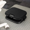 A black ergonomic footrest with a textured fabric top and adjustable base